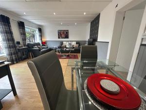 a living room with a glass table with a red plate on it at Solway Cottage in Annan