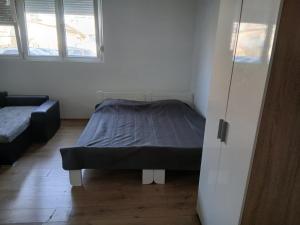 a small bedroom with a bed and a couch at Šimanovci- stan na dan in Šimanovci