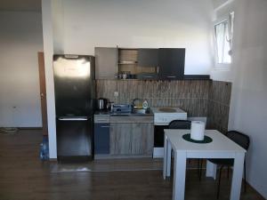 a kitchen with a refrigerator and a table with a white tableablish at Šimanovci- stan na dan in Šimanovci
