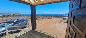a view from the front door of a house with a car at CABAÑA CON TINAJa in Guanaqueros
