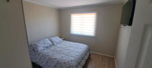 a small bedroom with a bed and a window at CABAÑA CON TINAJa in Guanaqueros