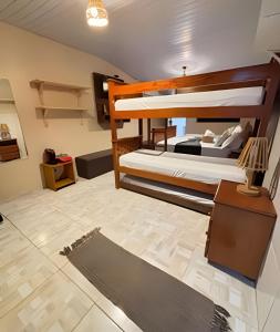 a room with two bunk beds and a rug at Sua Casa em Noronha - Conforto e Charme na Pousada da Iris in Fernando de Noronha