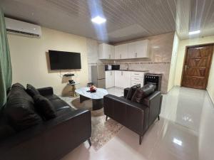 a living room with two couches and a table at Moima Plaza Guesthouse in Monrovia