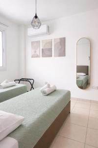 a bedroom with two beds and a mirror at Pantelia Apartment Paralimni in Paralimni +43 photos