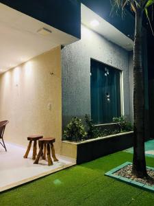 a room with two wooden benches and a tree at Casa Temporada Trairi in Trairi