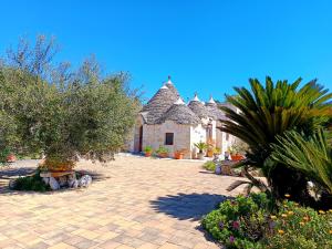 a courtyard of a house with trees and plants at B&B La Rosa dei Trulli Alberobello in Alberobello