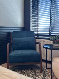 ein blauer Stuhl in einem Raum mit einem Tisch in der Unterkunft Hotel chic room in Heerlen + 8 Fotos