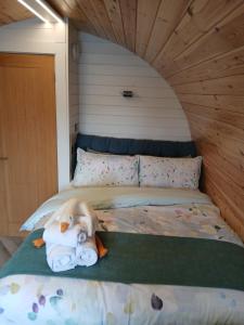 a bed with a teddy bear laying on it at Beinn View Pod in Corpach