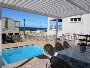 a patio with a table and a swimming pool at Turtle's Nest in Margate