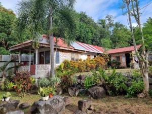 a house with palm trees in front of it at Penoria's lodge kubo in Mambajao