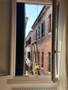 a window with a view of a brick building at B&B Al Pozzo di Luce in Venice
