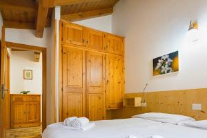 a bedroom with two beds and wooden cabinets at Appartamenti Leovacanze in Auronzo di Cadore