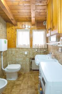 a bathroom with a toilet and two sinks in it at Appartamenti Leovacanze in Auronzo di Cadore +29 photos