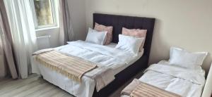 a bedroom with a bed with white sheets and pillows at Apartament Casa Dia Sibiu in Sibiu