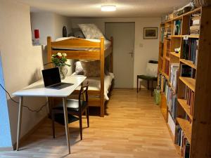 a room with a desk and a bunk bed with a laptop at Le Petit Ruisseau in Ollon