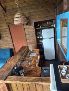 a kitchen with a counter and a refrigerator at Cabanas do Rio in Alfredo Wagner