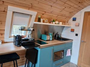 a kitchen with blue cabinets and a counter top at Beinn View Pod in Corpach