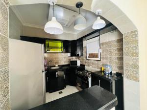 a kitchen with a black counter top and some lights at شاليه الفهدي in Sphinx International Airport