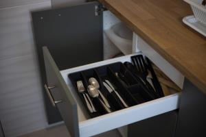 a drawer filled with utensils in a cabinet at Familija in Belgrade
