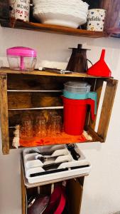 a refrigerator shelf with utensils and a coffee pot at Kitnet charmosa a 4 min da praia in Porto Seguro +8 photos