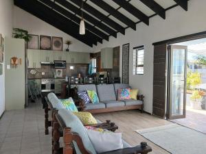 a living room with couches and a kitchen at Turtle's Nest in Margate