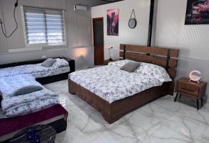 a bedroom with two beds and a table and a window at Bujtina Destan Doda in Librazhd