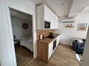 a kitchen with a sink and a bed in a room at la capeline in Chablis