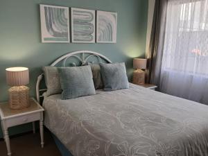 a bedroom with a bed with two lamps and a window at Turtle's Nest in Margate +33 photos