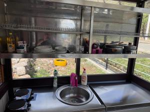 a kitchen counter with a sink and a window at Bujtina Destan Doda in Librazhd