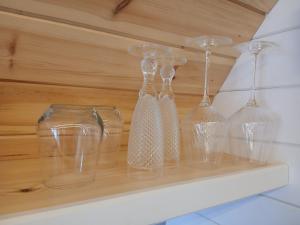 four glass wine glasses sitting on a shelf at Beinn View Pod in Corpach +31 photos