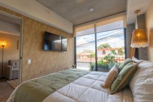 a bedroom with a large bed and a large window at Babylon Prime Nunciatura in San José