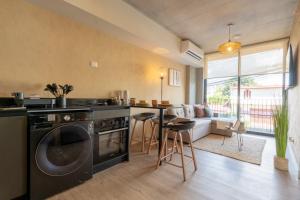 a kitchen with a washing machine and a living room at Babylon Prime Nunciatura in San José