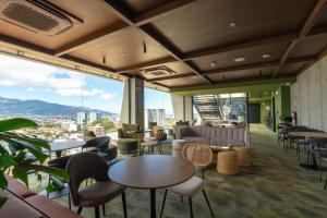 a restaurant with tables and chairs and a view of a city at Babylon Prime Nunciatura in San José