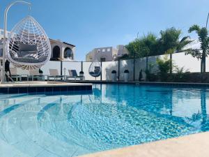 a large swimming pool with a chair in front of a building at Villa Dreamy Pool Garden in Eilat