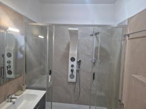a shower with a glass door next to a sink at Villa Criade in Castelsardo