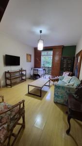 a living room with a couch and a table at duplex aconchegante com varanda em condominio in Nova Friburgo