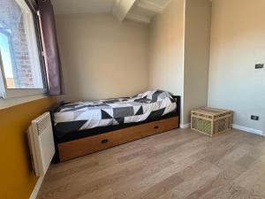 a small bedroom with a bed and a window at Le Saint Sauveur - centre ville in Péronne