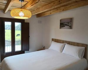 a bedroom with a white bed and a window at ALOJAMIENTO MONTE EDILLA Naturaleza, Confort y Recarga Eléctrica in Quintana de los Prados