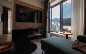 a living room with a large window and a tv at SkyHill Jahorina Poljice Gondola in Jahorina