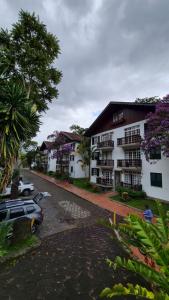 a building with a car parked next to a street at duplex aconchegante com varanda em condominio in Nova Friburgo