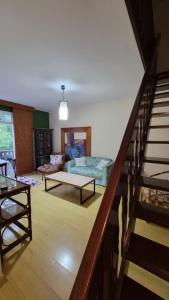 a living room with a staircase and a couch at duplex aconchegante com varanda em condominio in Nova Friburgo
