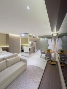 a living room with a couch and a dining room at FR1307B Estúdio alto padrão com cama king e garagem in Goiânia