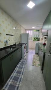 a large kitchen with a sink and a refrigerator at duplex aconchegante com varanda em condominio in Nova Friburgo