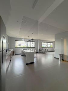a large white room with a table and chairs at FR1307B Estúdio alto padrão com cama king e garagem in Goiânia