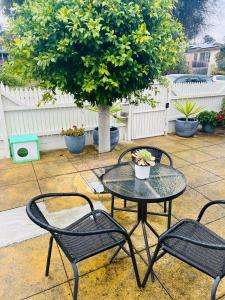 a patio with two chairs and a table and a tree at ABC Homes Nedlands in Doncaster East