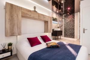 a bedroom with a large white bed with red pillows at Le Bocca Port Nature - Vue mer - coursive - Parking - Clim - Village Naturiste in Cap d'Agde +8 photos