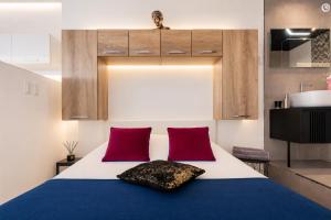 a bedroom with a bed with two red pillows at Le Bocca Port Nature - Vue mer - coursive - Parking - Clim - Village Naturiste in Cap d'Agde