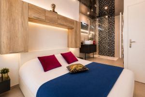 a bedroom with a large white bed with red pillows at Le Bocca Port Nature - Vue mer - coursive - Parking - Clim - Village Naturiste in Cap d'Agde