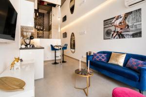 a living room with a blue couch and a tv at Le Bocca Port Nature - Vue mer - coursive - Parking - Clim - Village Naturiste in Cap d'Agde