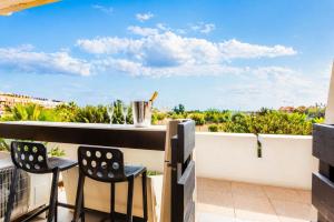 a balcony with a bar and two chairs at Le Bocca Port Nature - Vue mer - coursive - Parking - Clim - Village Naturiste in Cap d'Agde